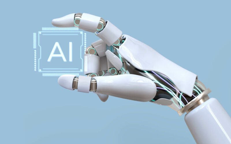 AI - jak korzystać ze sztucznej inteligencji. Ręka robota trzyma płytkę z napisem AI.